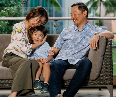 Family of three sitting on a sofa